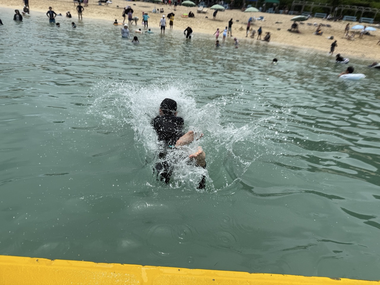 伊計ビーチで海に飛び込み水しぶきをあげる子ども