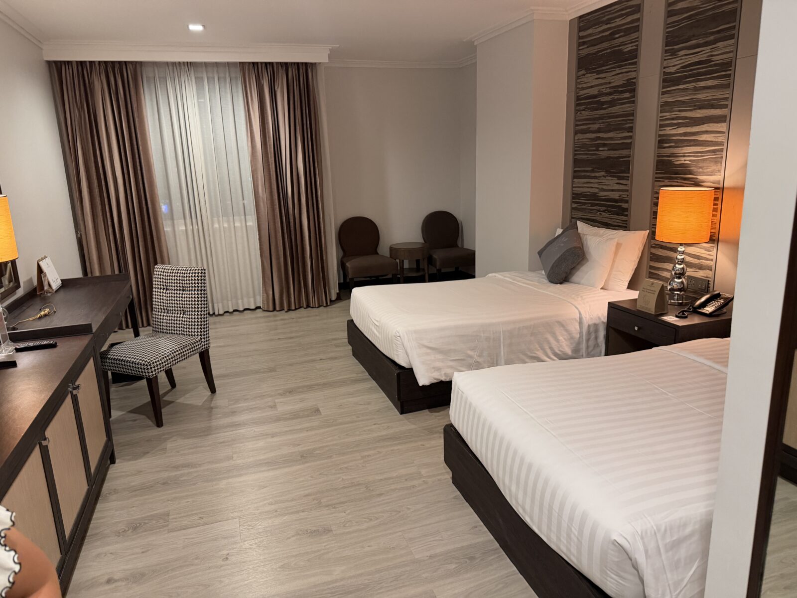 バークレーホテルのPremier Roomの全景。シングルベッド2台、デスクと椅子、カーテンのかかった窓が見える