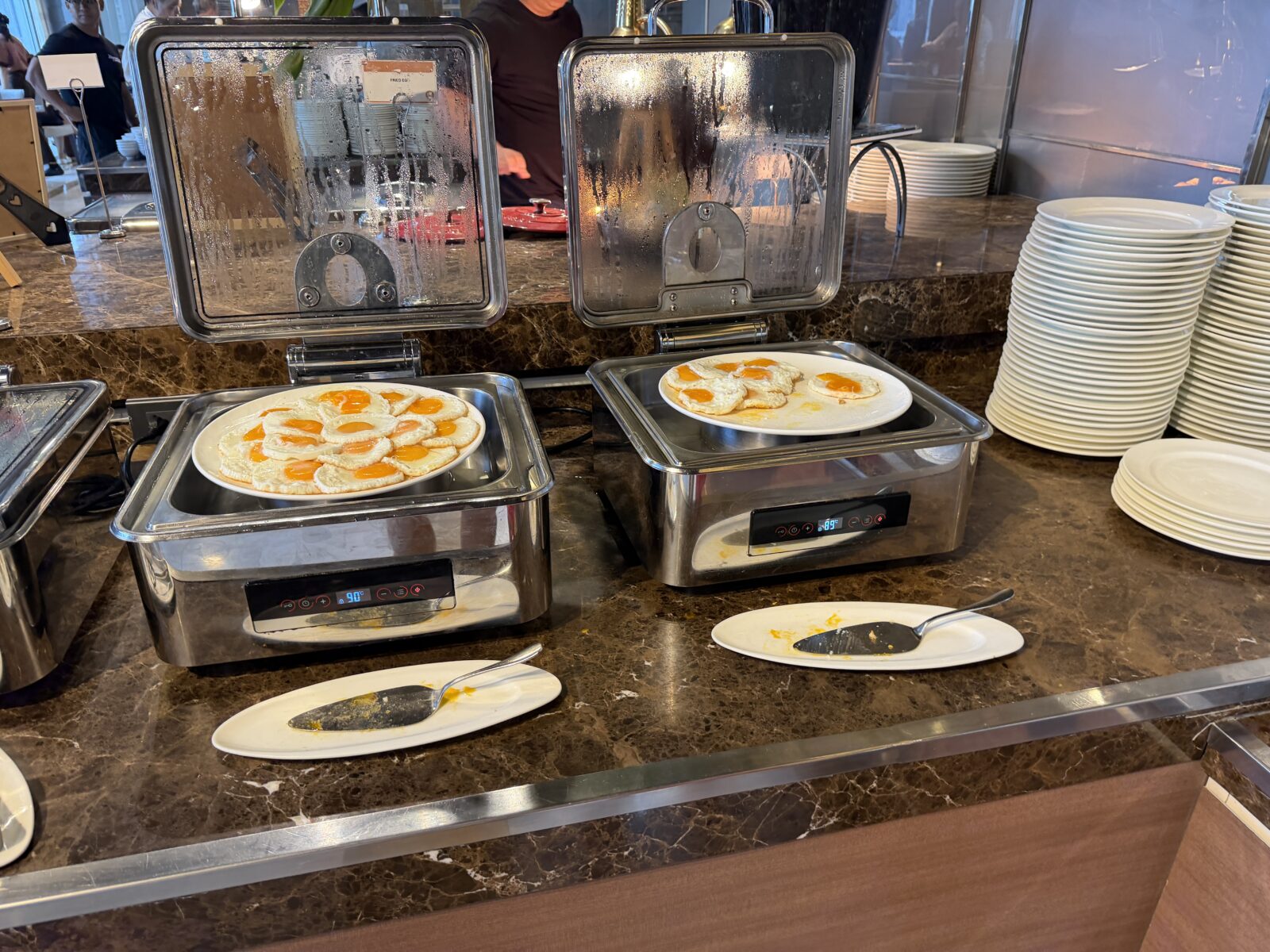 バークレーホテルの朝食の目玉焼き。2つの保温トレーに並び、奥に皿が積まれている
