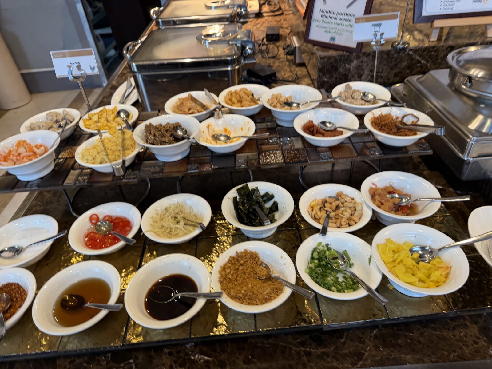 バークレーホテルの朝食にある中華粥の薬味コーナー。青ねぎ、揚げにんにく、干しエビ、しょうゆ、卵などが20種類ほど小鉢で並ぶ