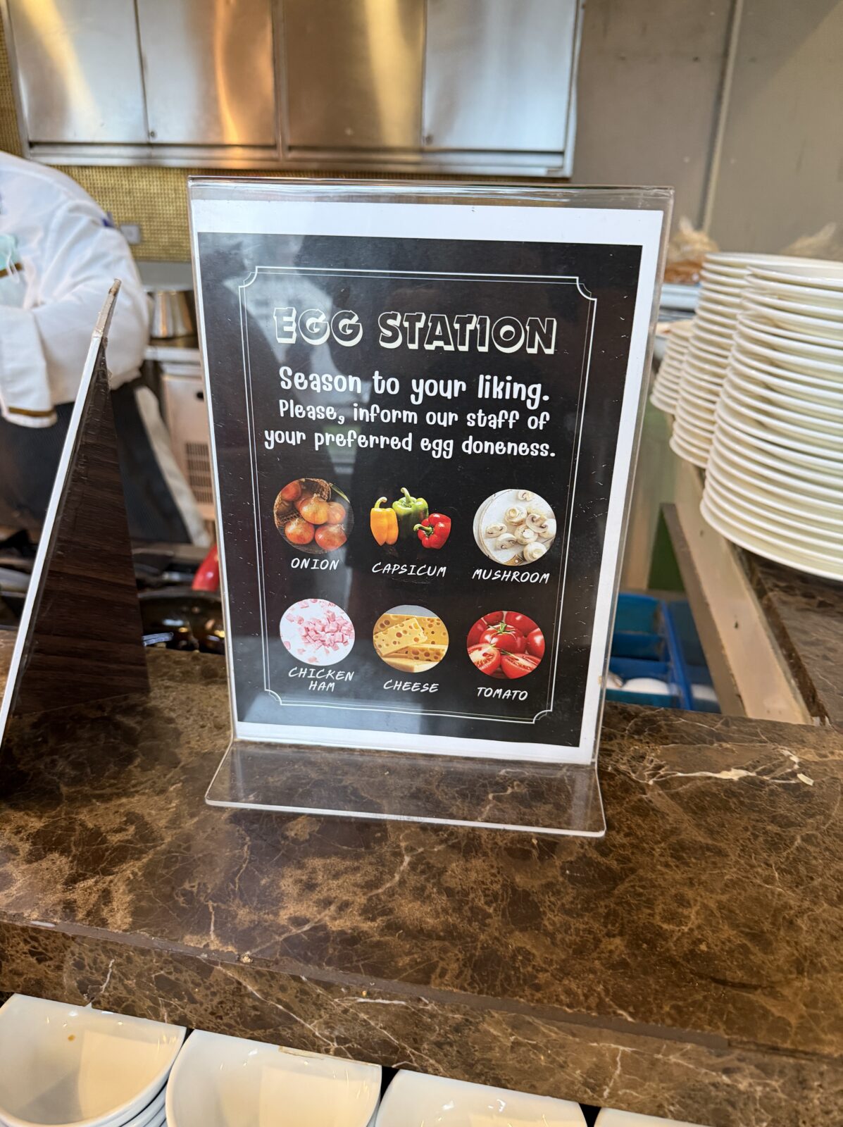 バークレーホテルの朝食のエッグステーションの案内。玉ねぎ、パプリカ、マッシュルーム、チキンハム、チーズ、トマトが写真で示されている