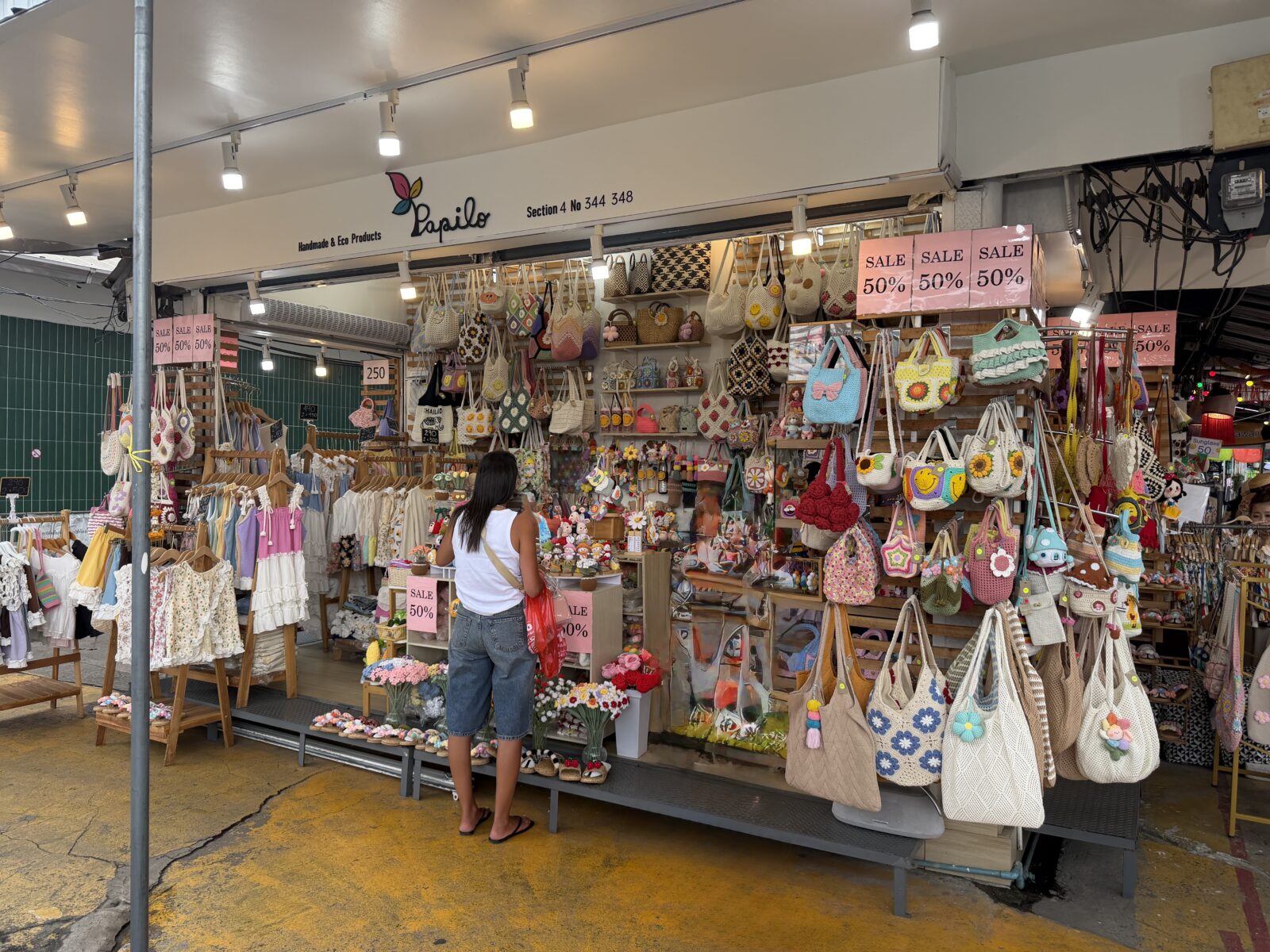 チャトゥチャック市場の革小物とバッグの店。トートバッグやポーチが壁一面に吊るされている