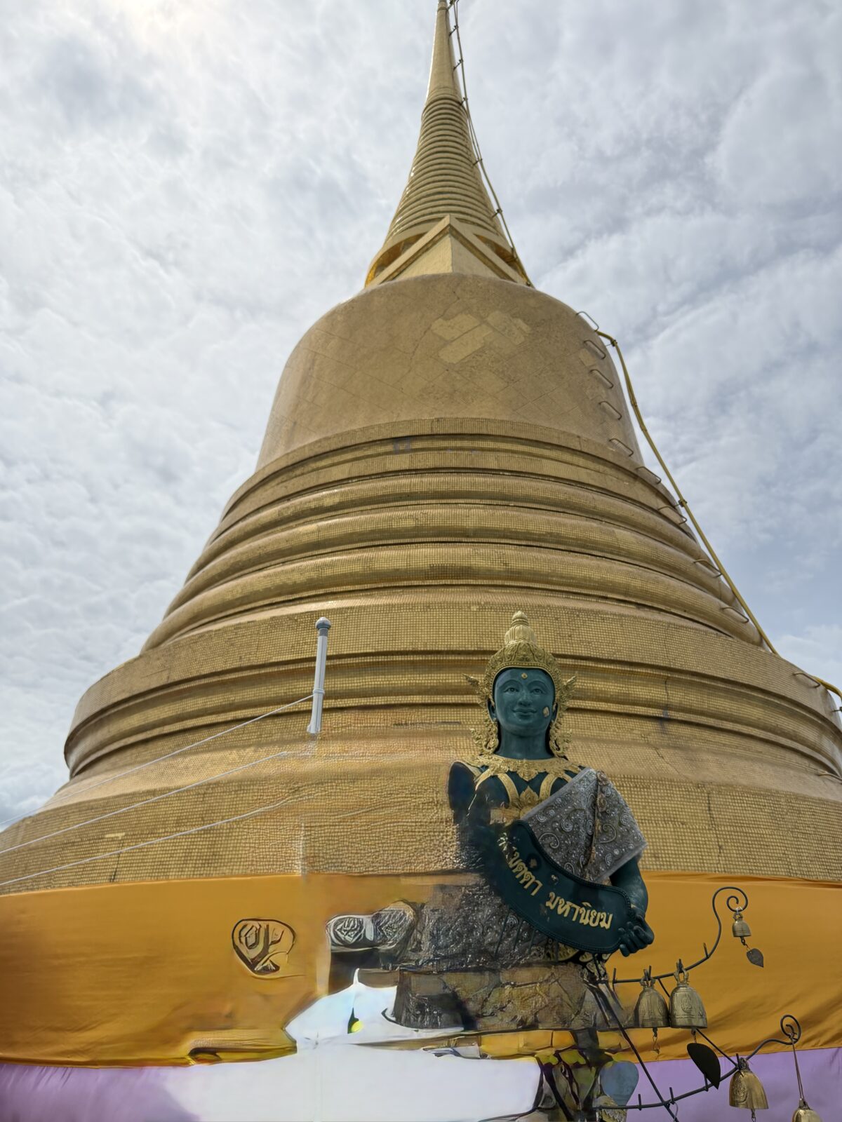 ワット・サケットの黄金の仏塔を見上げたところ。金色の塔と青い仏像が写っている