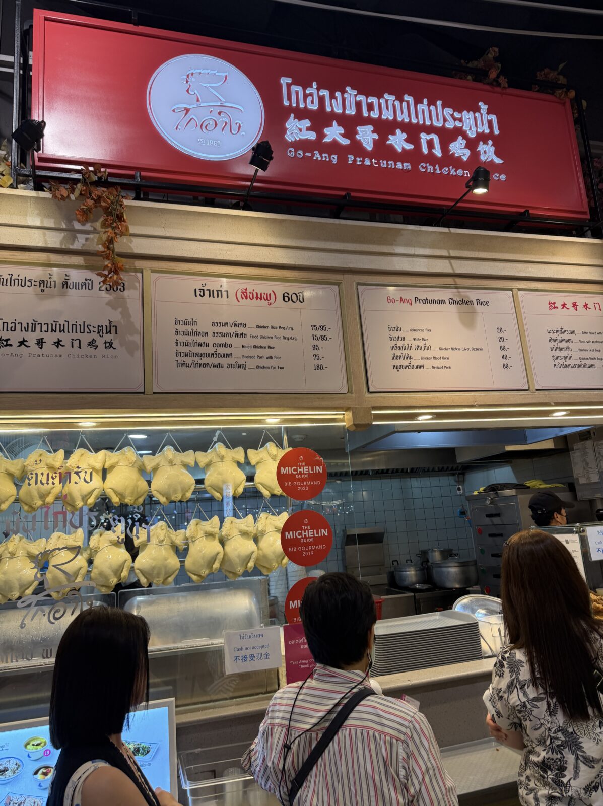 サイアムパラゴンのフードコートにあるカオマンガイの店。券売機の上に商品写真のメニューが並ぶ