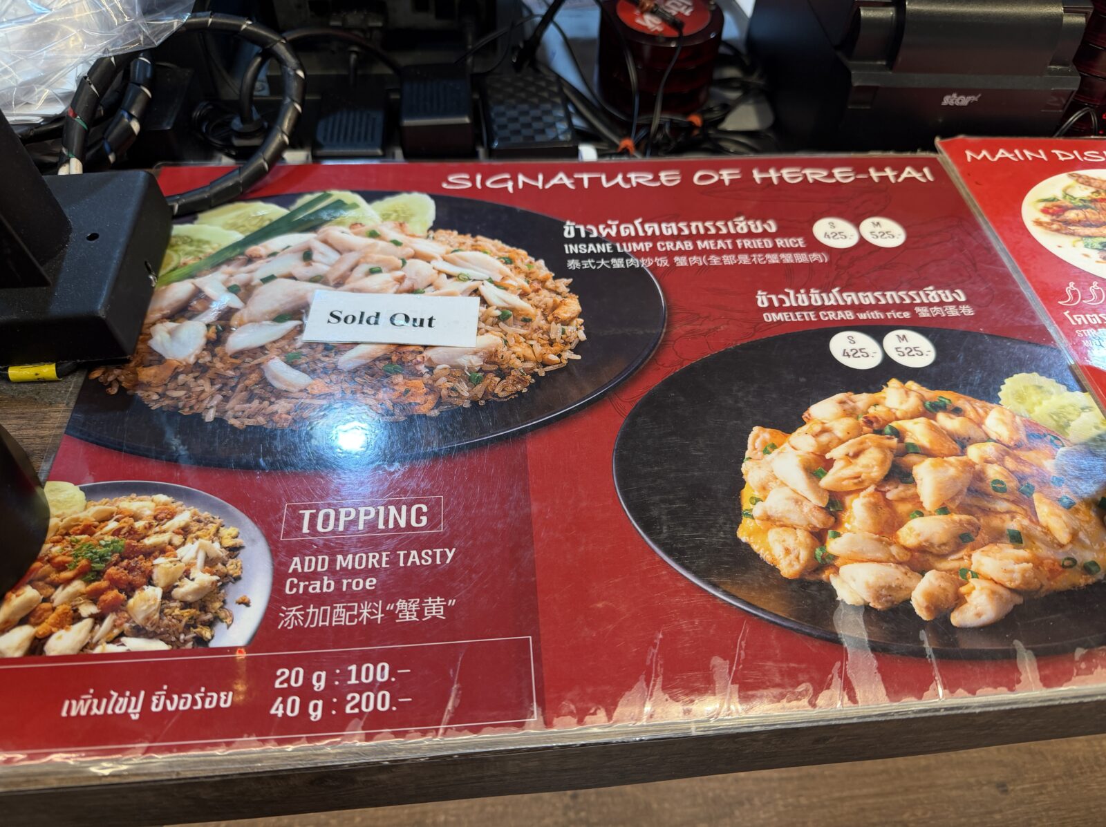 Here Haiのメニュー看板。カニの身をたっぷり使ったチャーハンとカニ入りオムレツの写真が並ぶ