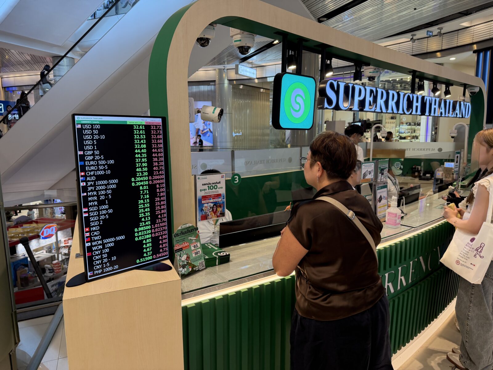 SuperRichの両替所のカウンター。緑の看板の下にレート表のモニターが並んでいる