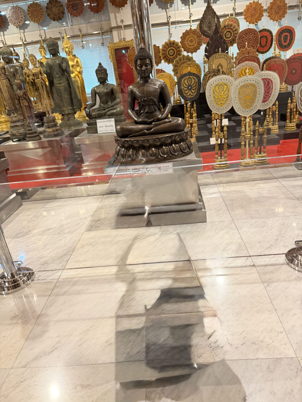 ワット・パクナムの堂内。金色の仏像が並び、壁に円形の装飾がいくつも掛けられている