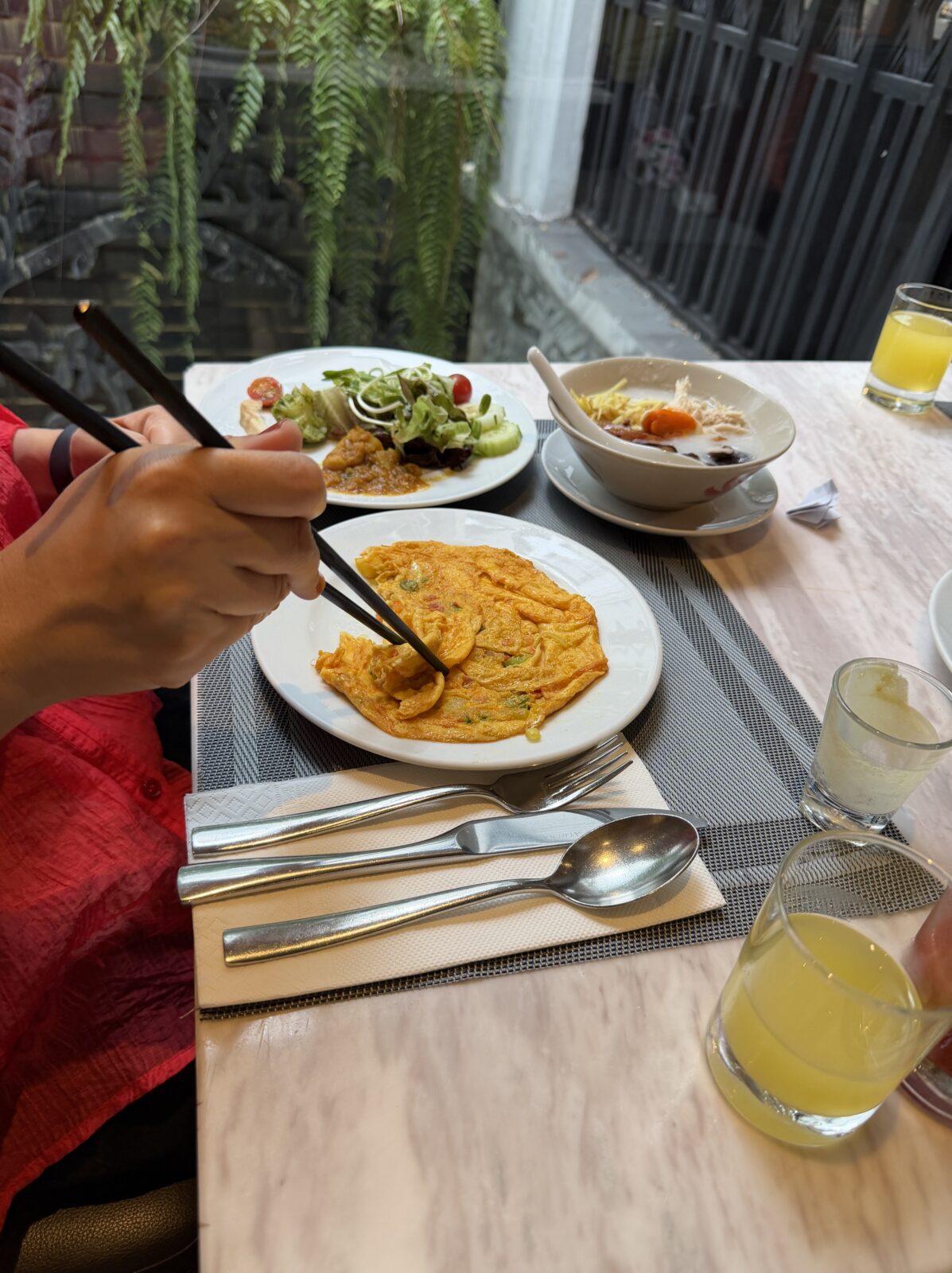 モーベンピックの朝食で運ばれてきたオムレツとサラダ、ジュースの皿