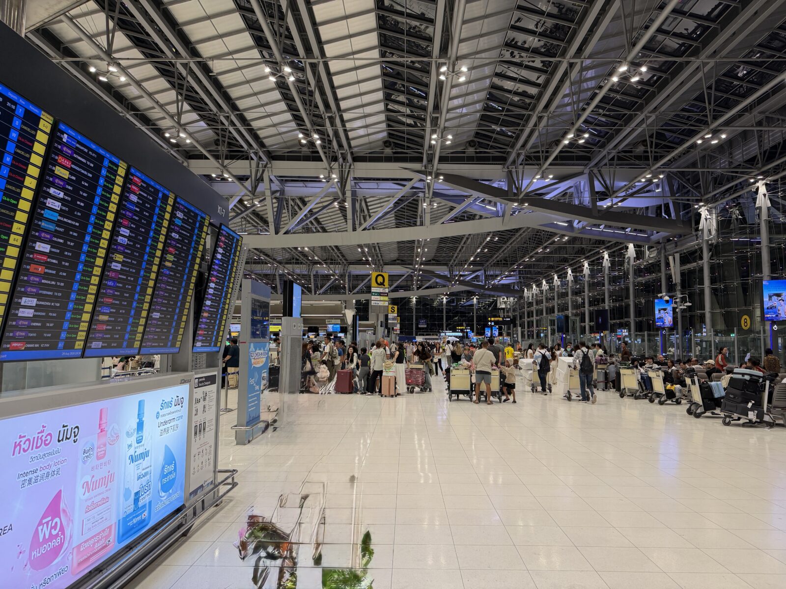 スワンナプーム空港の出発フロア。天井の高いホールに大きなフライト情報の掲示板が並んでいる