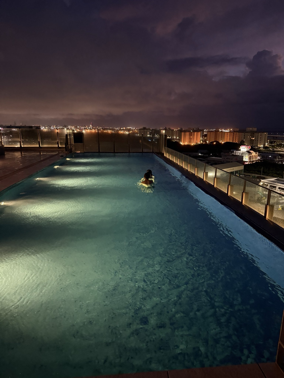 アラクージュ浦添のプール。夜景を背にライトアップされた水面