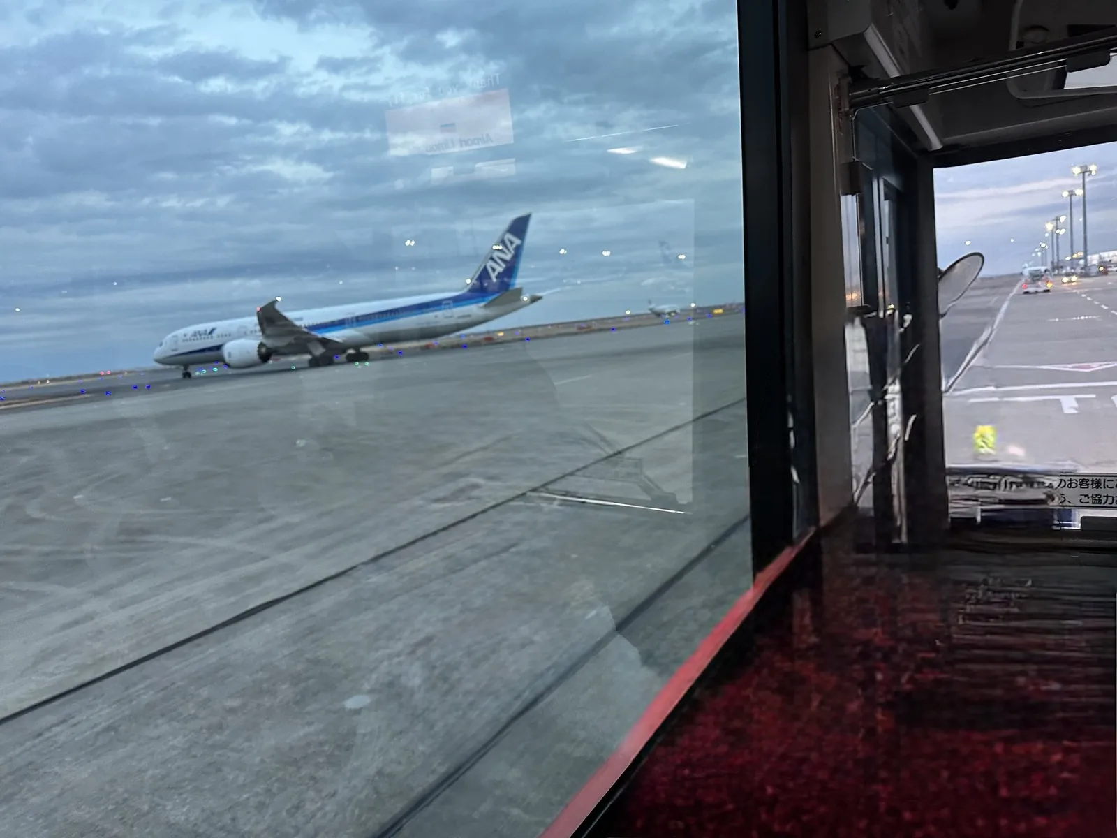 空港の窓越しに見えるANAの飛行機