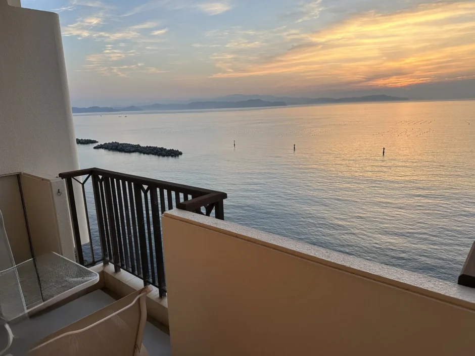 アオアヲナルトリゾートのオーシャンビューの客室のバルコニーから見た、夕日に染まる鳴門の海と防波堤