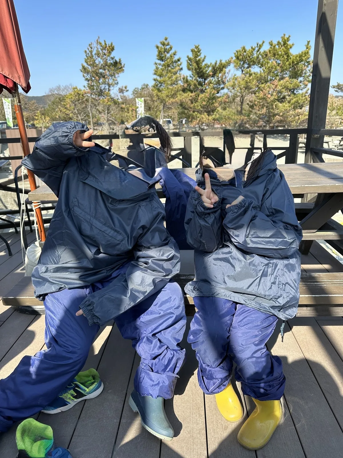 わかめ漁に出る前、上下の雨具を着た子ども2人