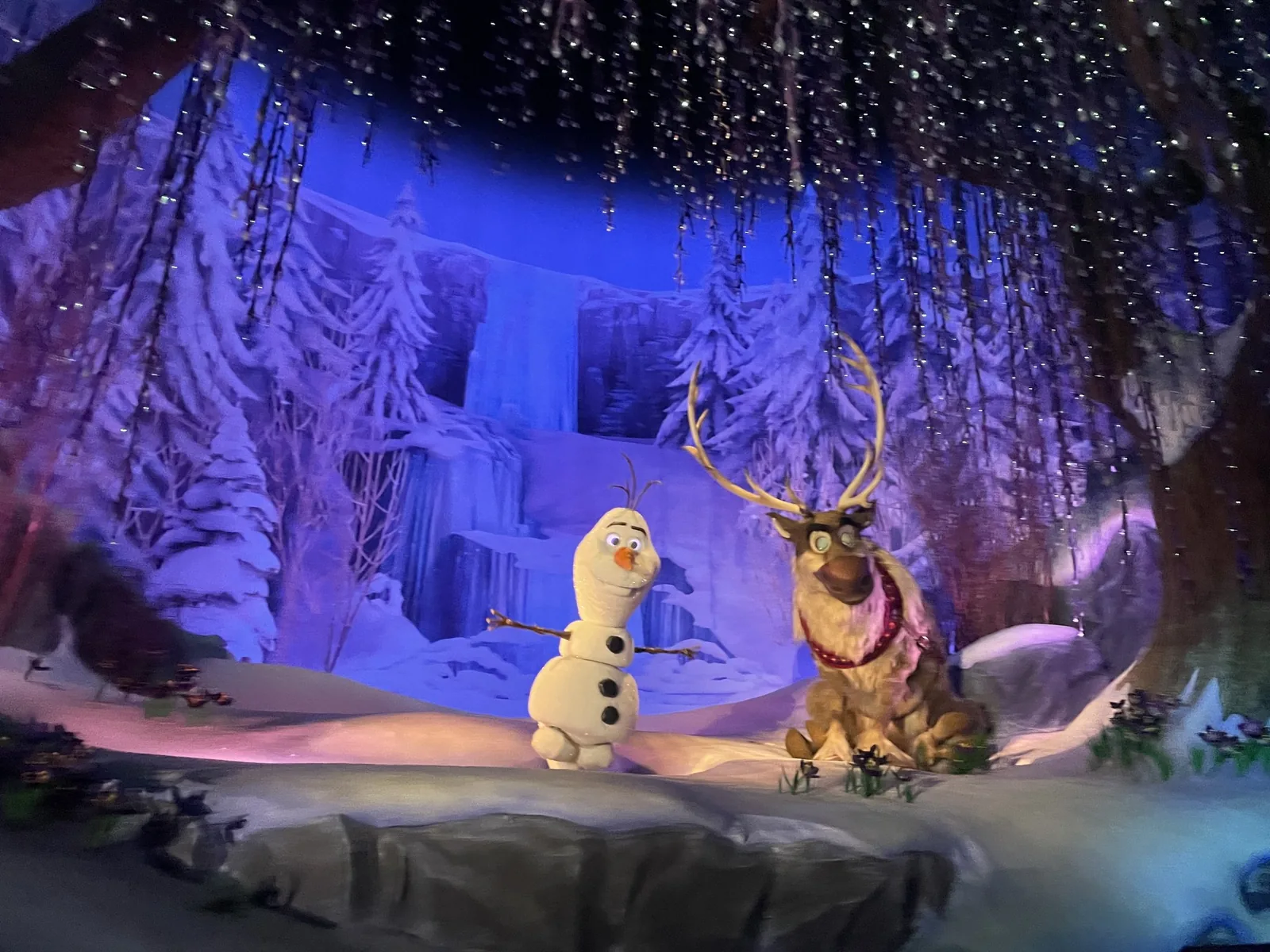 フローズン・エバー・アフターの中の雪の場面。オラフとトナカイのスヴェンが並んでいる