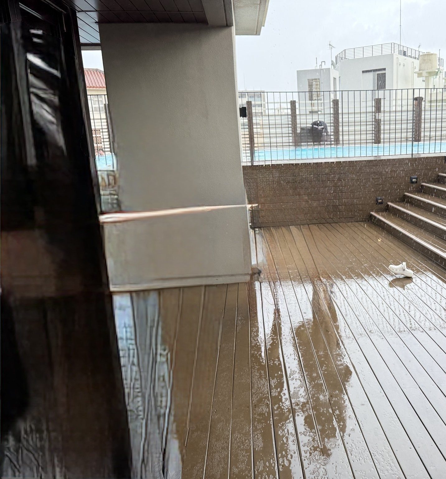 雨に濡れたハイアットリージェンシー那覇のプールサイドのデッキ