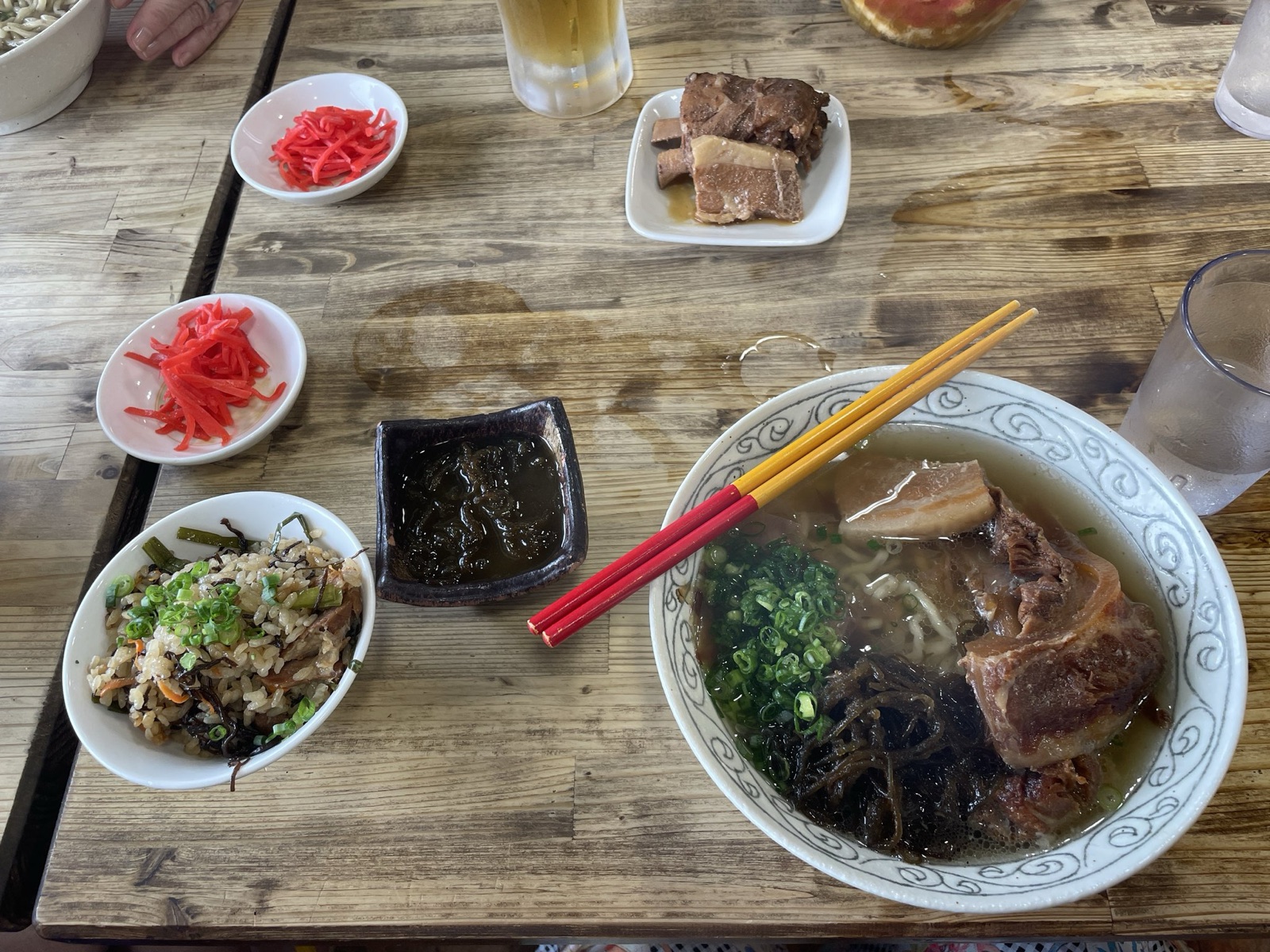 海中茶屋のソーキそばと沖縄の炊き込みご飯、もずく、紅生姜が並んだテーブル