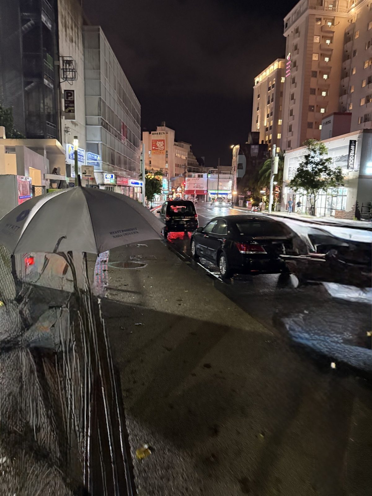 雨の夜の国際通り。歩道に傘が置かれている
