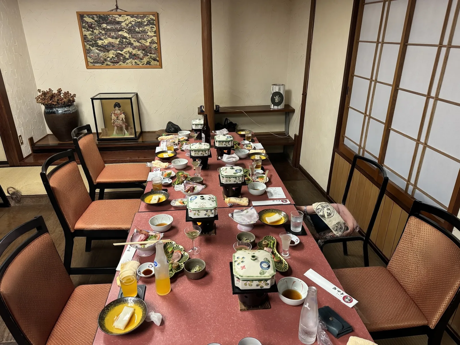 古山閣の夕食の席。障子のある部屋に長いテーブルと椅子が並び、小鍋や小鉢が置かれている
