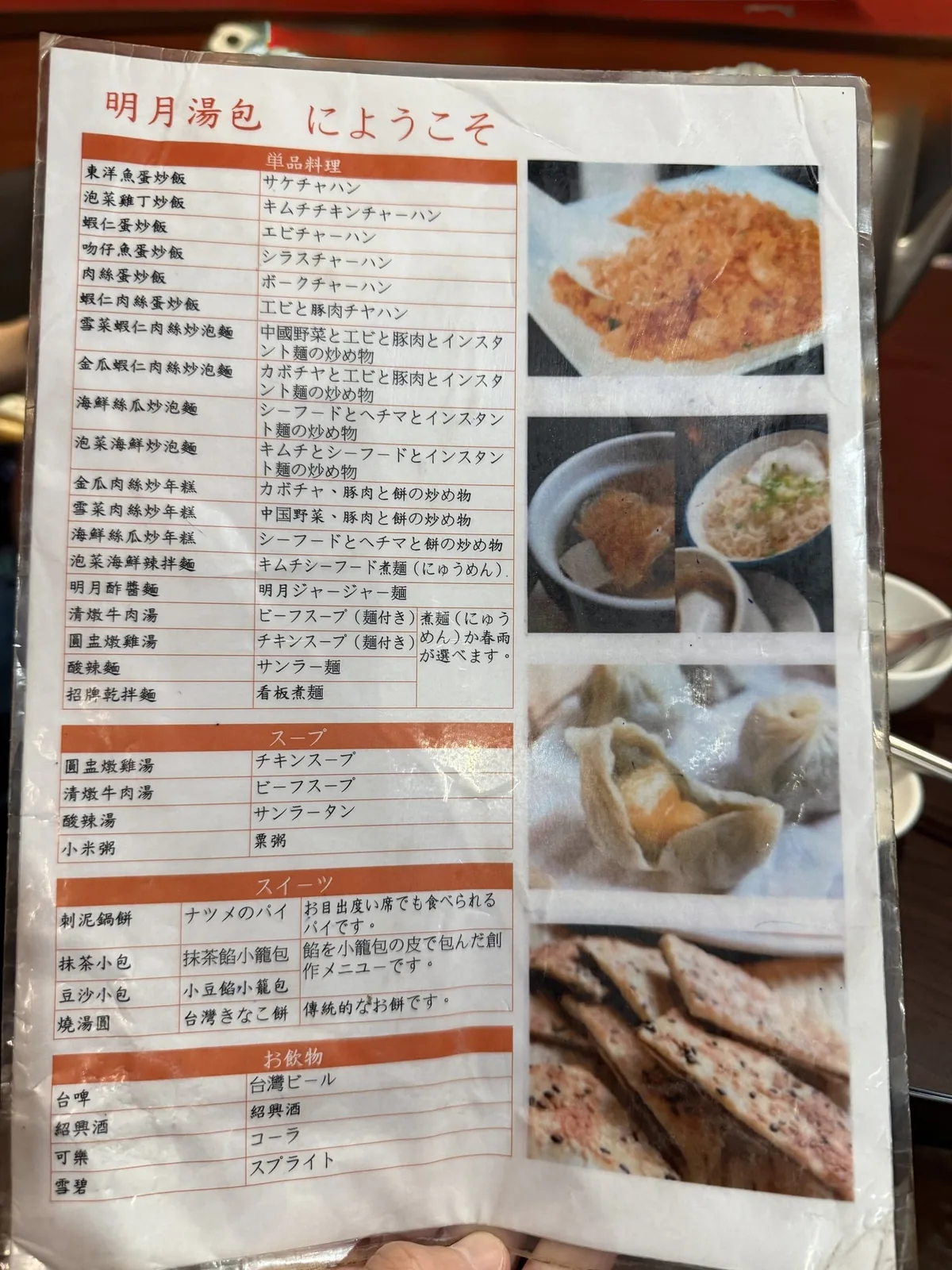 明月湯包のメニュー。料理の写真と日本語の説明が並び、小籠包や麺類の価格が載っている