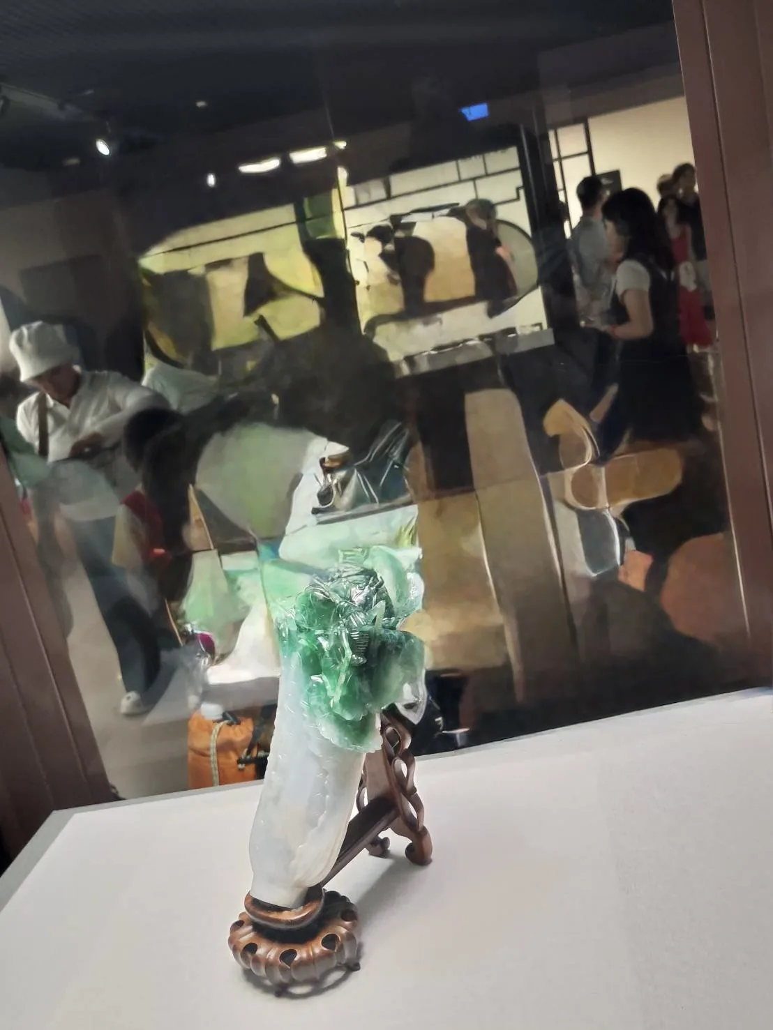 国立故宮博物院の展示室。ガラスケースに入った玉(ぎょく)の彫刻が、暗い室内で照らされている