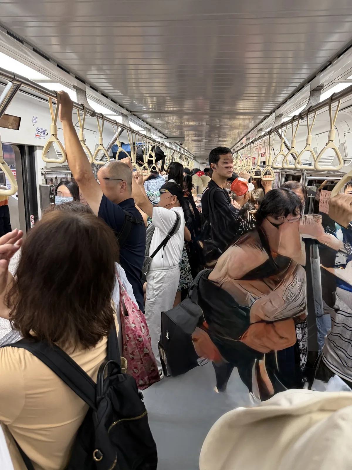 十分へ向かう平溪線の車内。吊り革や手すりにつかまった乗客で通路までいっぱいになっている土曜の様子