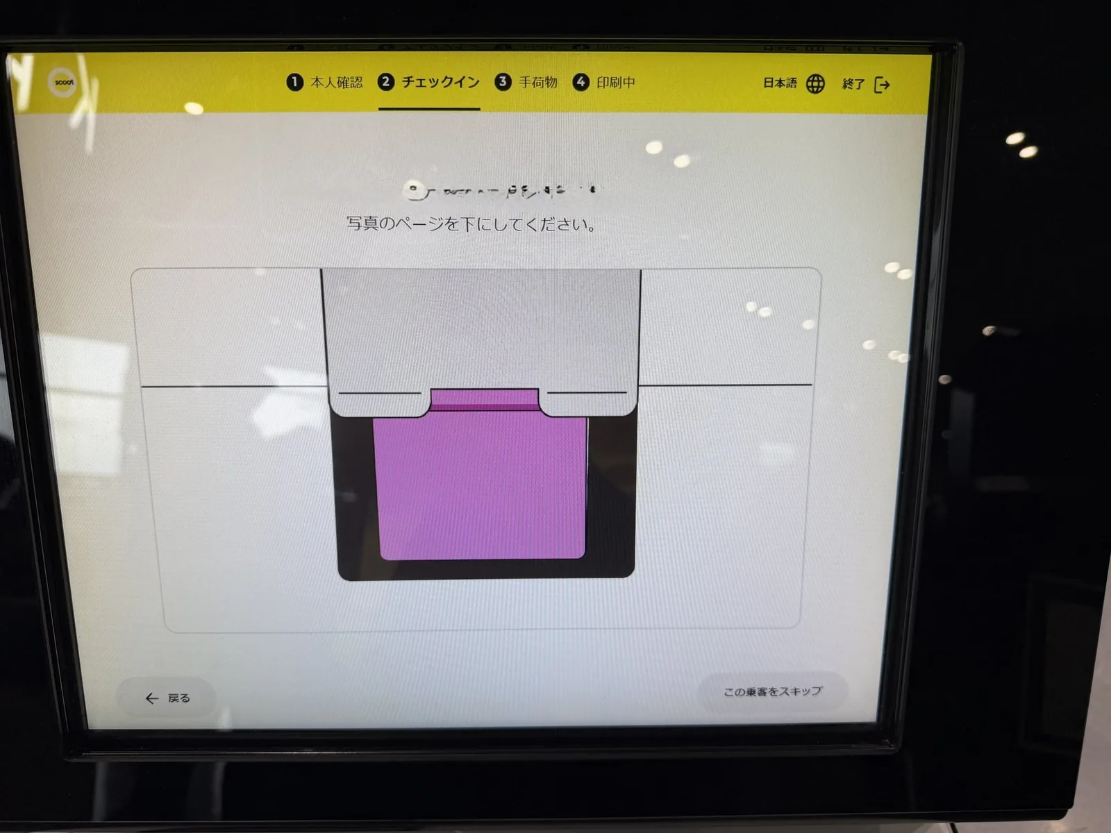 スクートのセルフキオスクの画面。写真のページを下にしてください、とパスポートの置き方を案内している