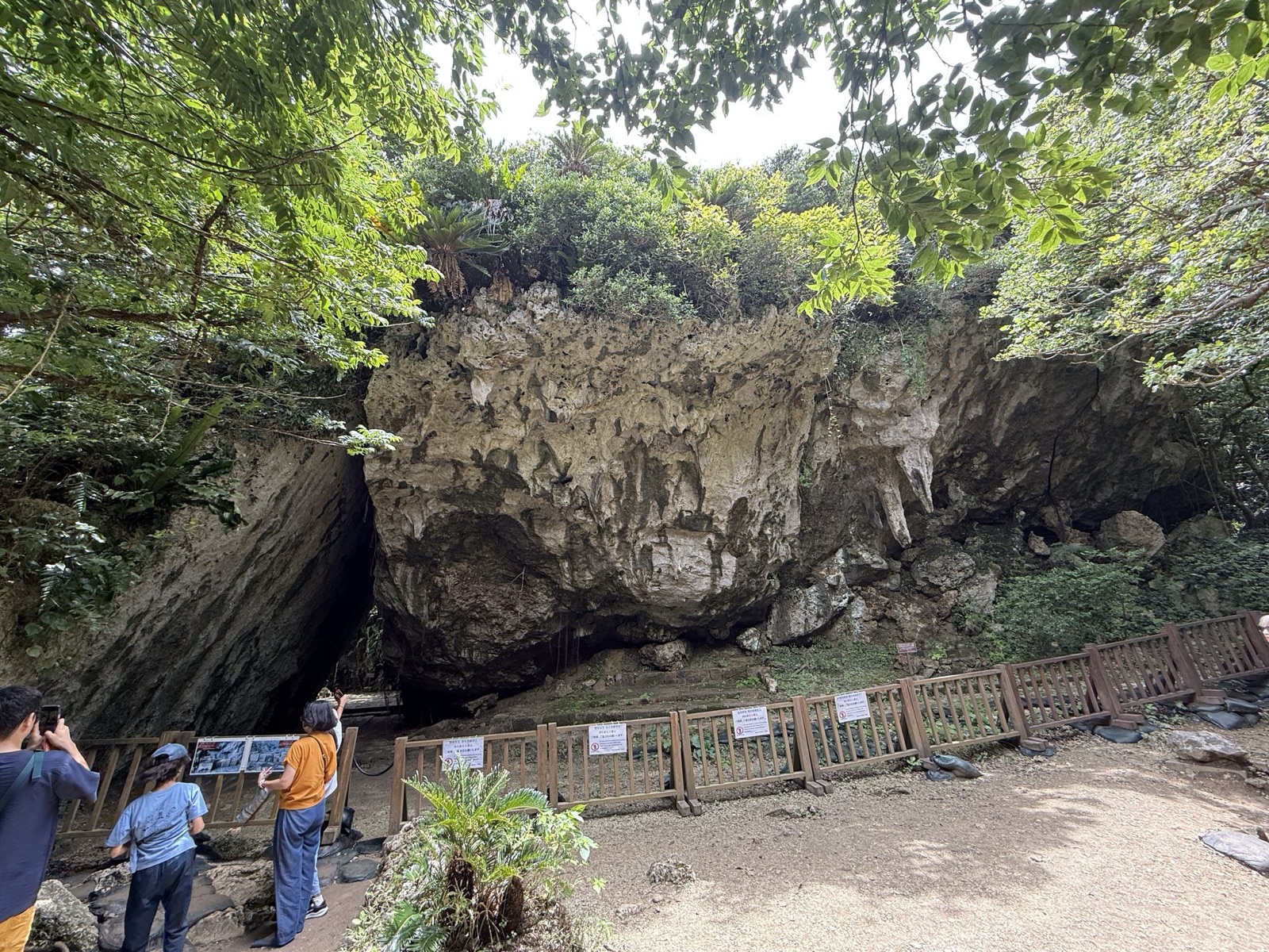 斎場御嶽の大きな岩壁と、その下に続く柵のついた見学路