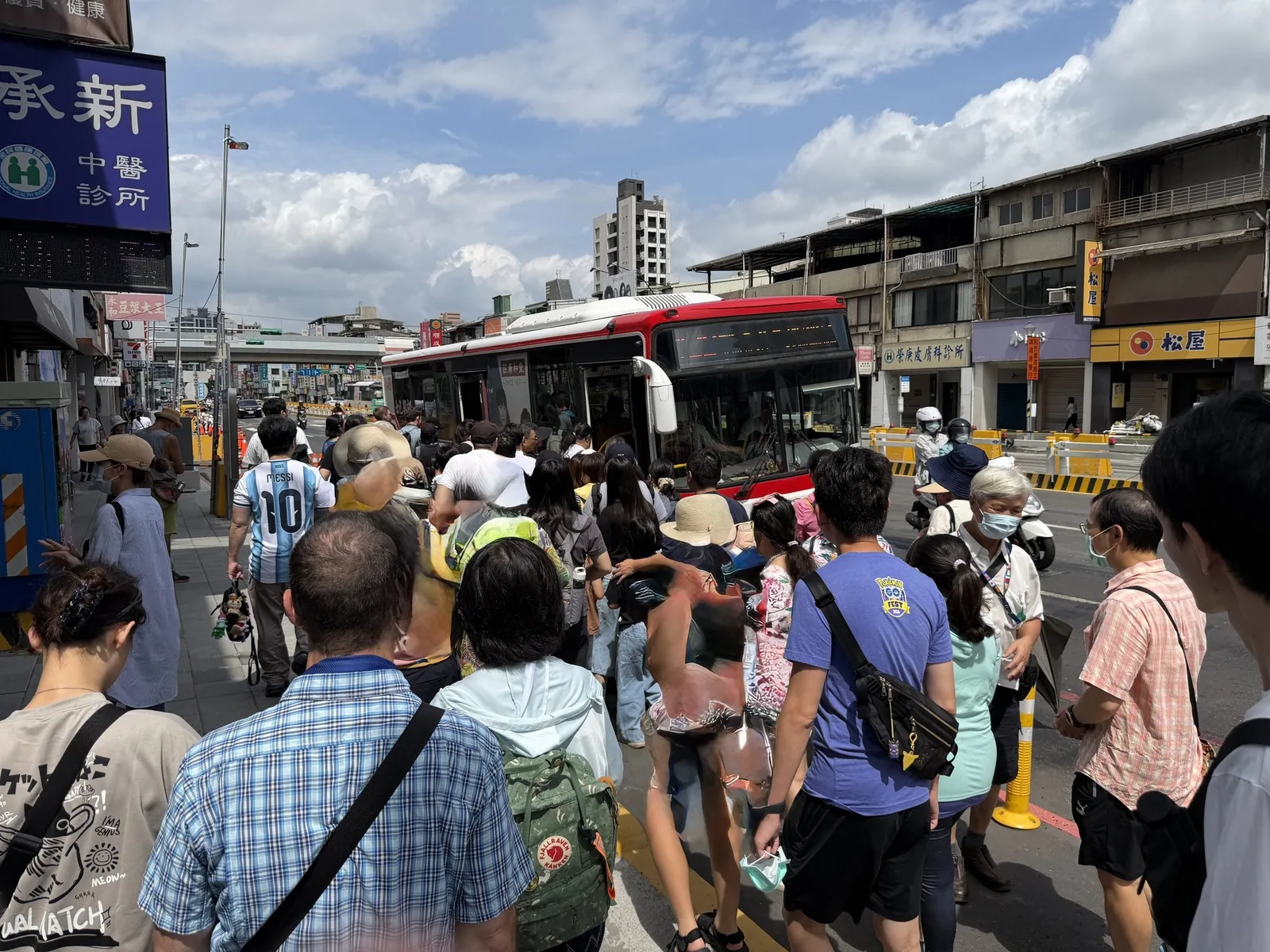 士林駅前のバス停に並ぶ長い列。故宮博物院行きのバスを待つ人が歩道にあふれている様子