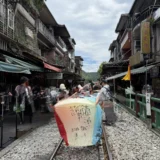 十分の線路の上に置かれた四色の天燈。日本語で書かれた願い事と日付が大きく写っている