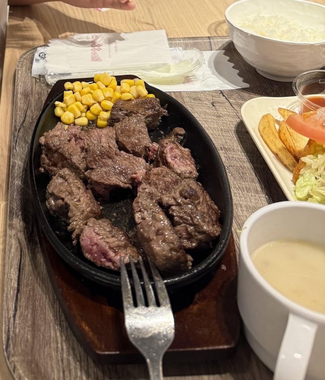1000円ステーキ88の鉄板に載った牛肉とコーン