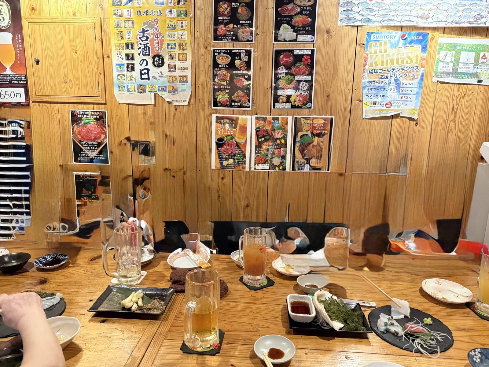 沖縄居酒家すんのテーブル。ビールと沖縄料理が並ぶ