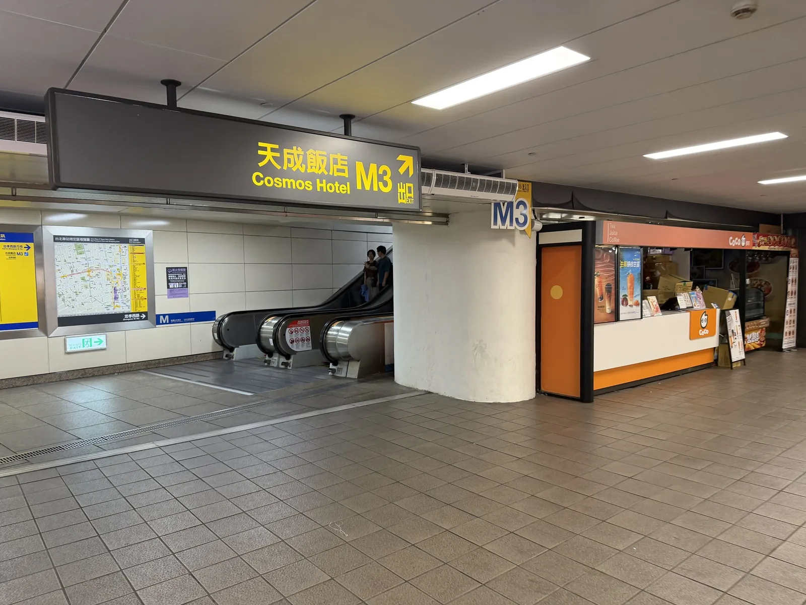台北駅の地下通路から見たM3出口。天成大飯店(コスモスホテル台北)への案内看板とエスカレーターが並んでいる