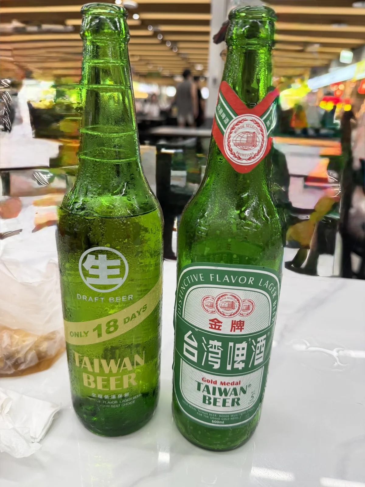 テーブルに並んだ台湾ビール2本。左は賞味期限18日の生ビール、右は金牌台湾啤酒のラベル