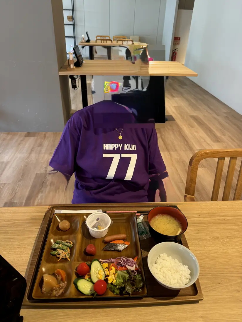 翌朝の食卓に置かれた喜寿の紫のTシャツと朝食のトレー