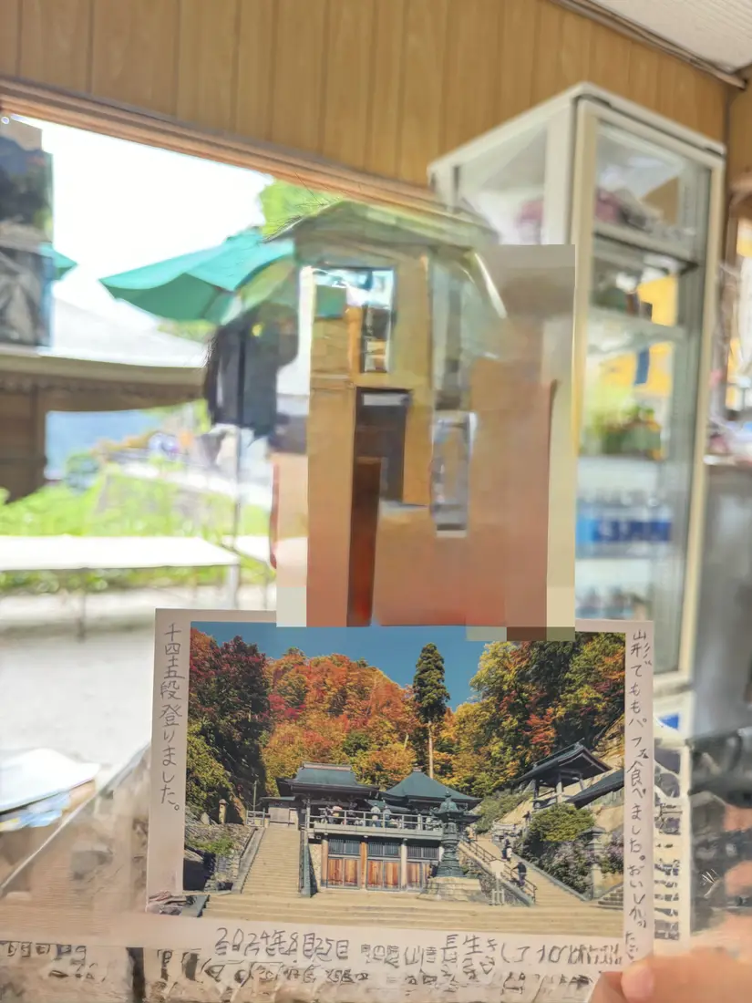 山寺のふもとの土産物店。店先に紅葉の風景写真が飾られている