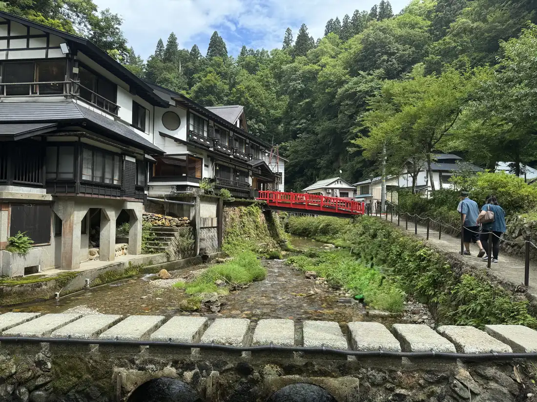 銀山温泉の街並み。川の両側に木造の旅館が並び、赤い橋が架かっている