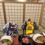 喜寿と傘寿のお祝いTシャツを掛けた椅子と、山形牛の夕食が並ぶ旅館の和室