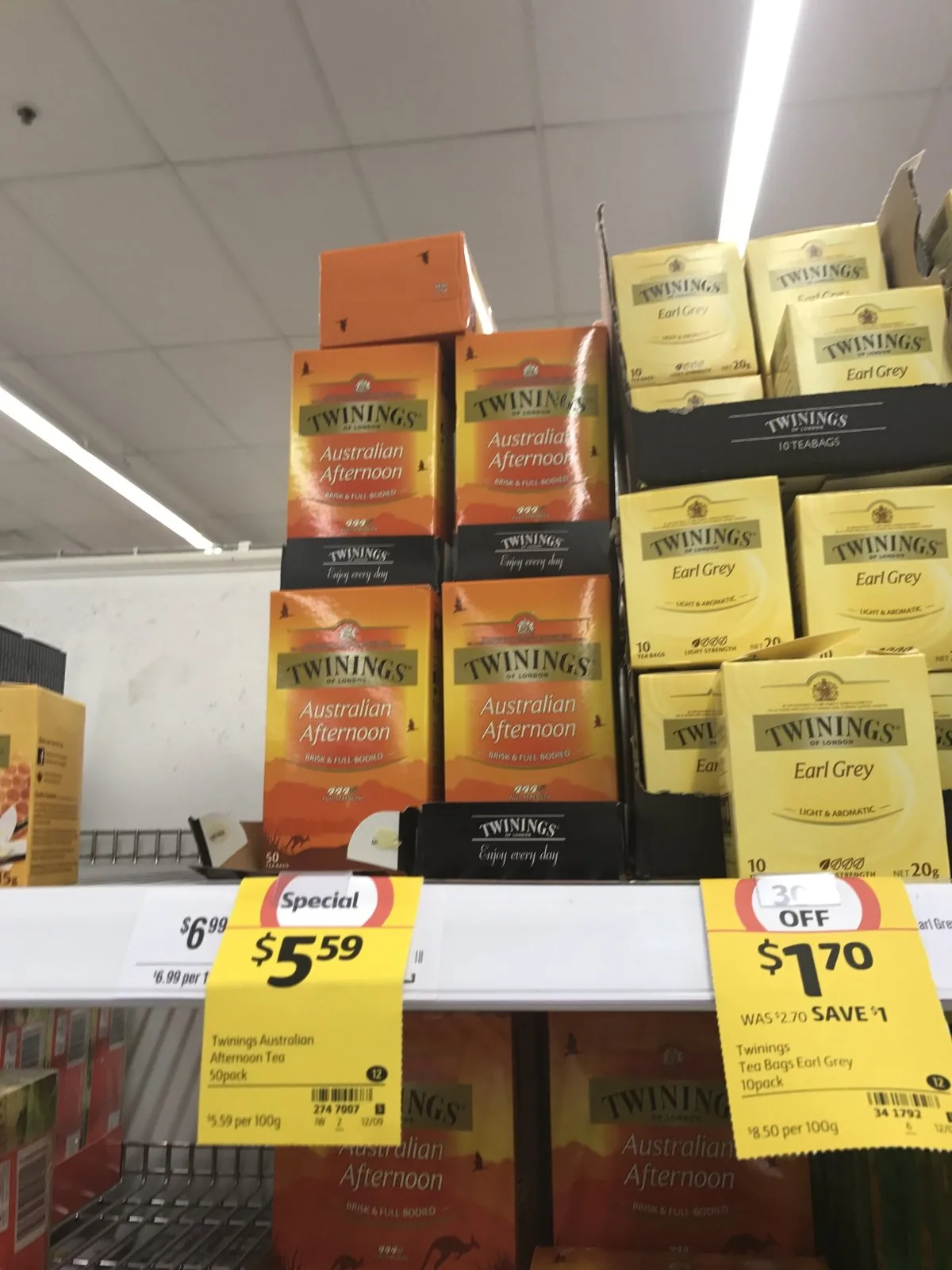 Boxes of Twinings Australian Afternoon and Earl Grey tea with yellow price tags on a supermarket shelf