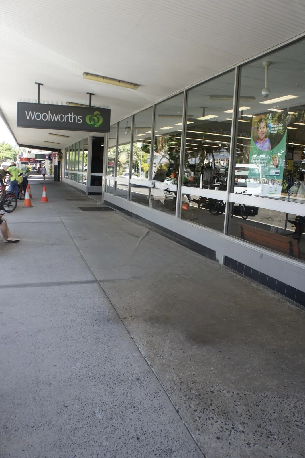 The Woolworths supermarket sign and glass storefront facing a covered walkway