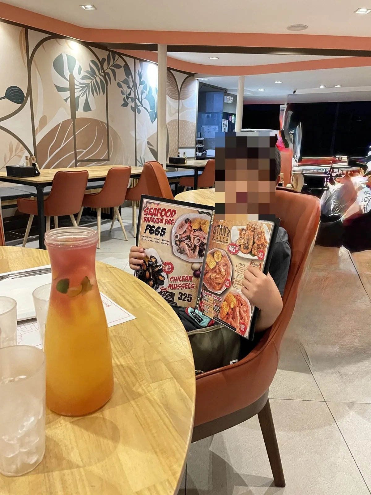 CHOOBI CHOOBI の席でメニューを広げる子ども(顔はモザイク)とピッチャーの飲み物