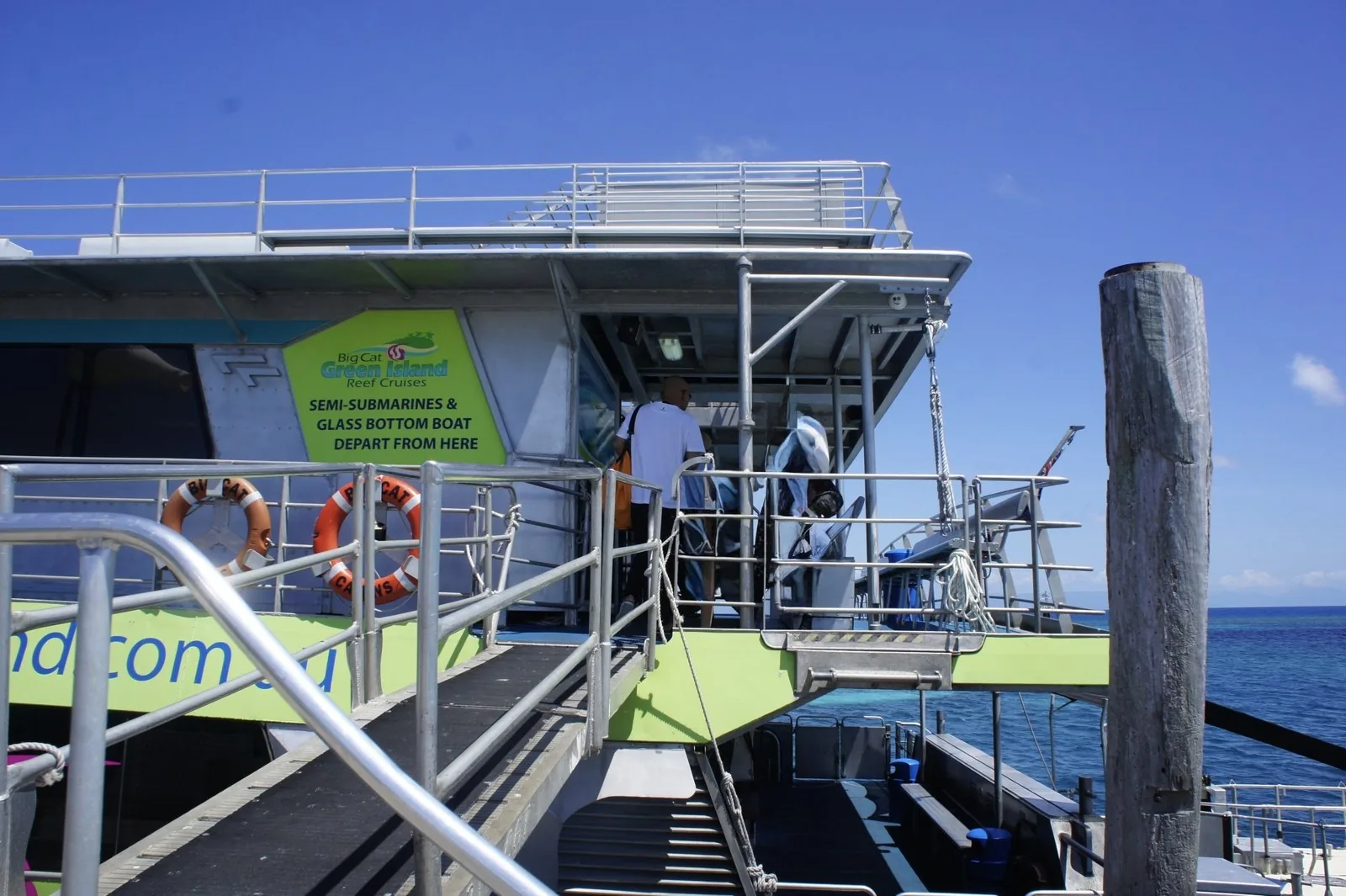 グリーン島の桟橋に停まるビッグキャットの船と、半潜水艦とグラスボトムボートの乗り場を示す緑の看板