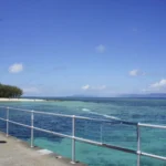 ケアンズ沖のグリーン島で、桟橋の手すり越しに見たエメラルド色の浅い海と白い砂浜(2017年9月)