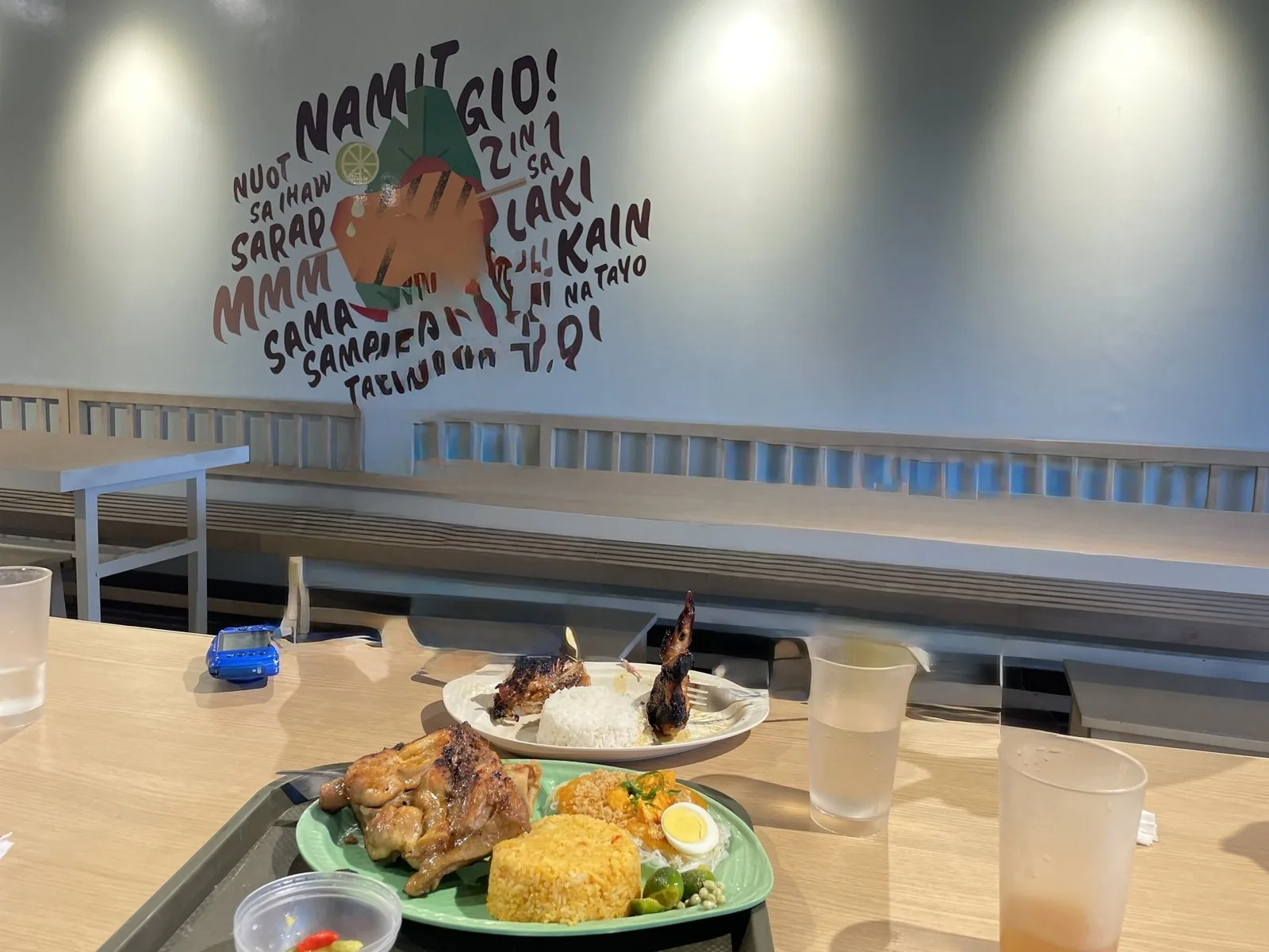Mang INASAL の皿。炭焼きのチキンと黄色いご飯、ゆで卵が載っている