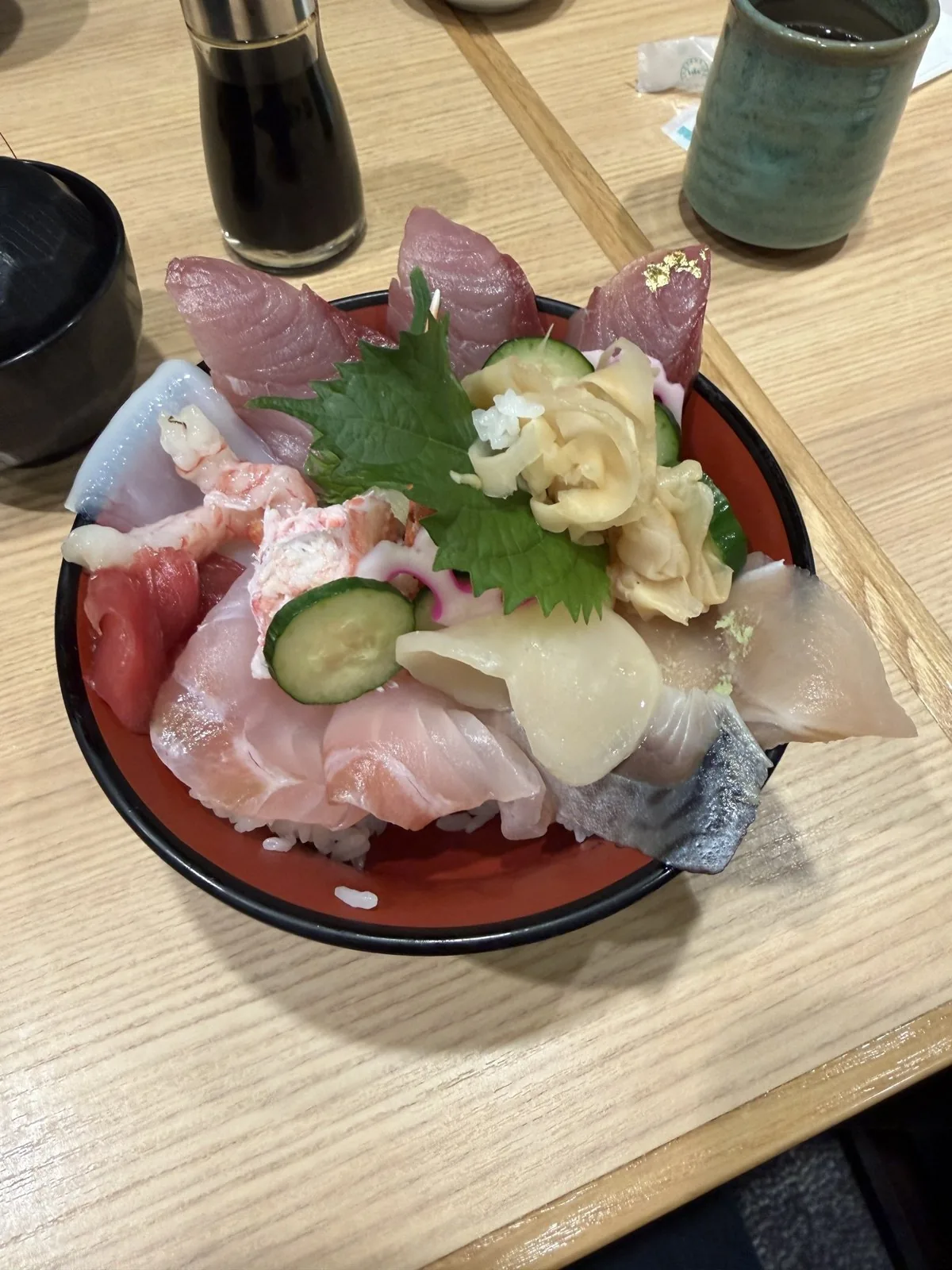 器に盛られた海鮮丼。マグロやイカ、エビ、カニ、しめさばなどがのり、上に金箔が飾られている