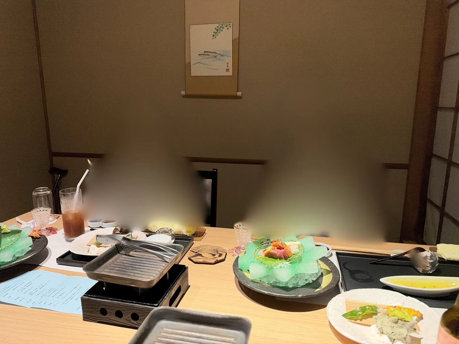 個室のテーブルに並んだ夕食の皿