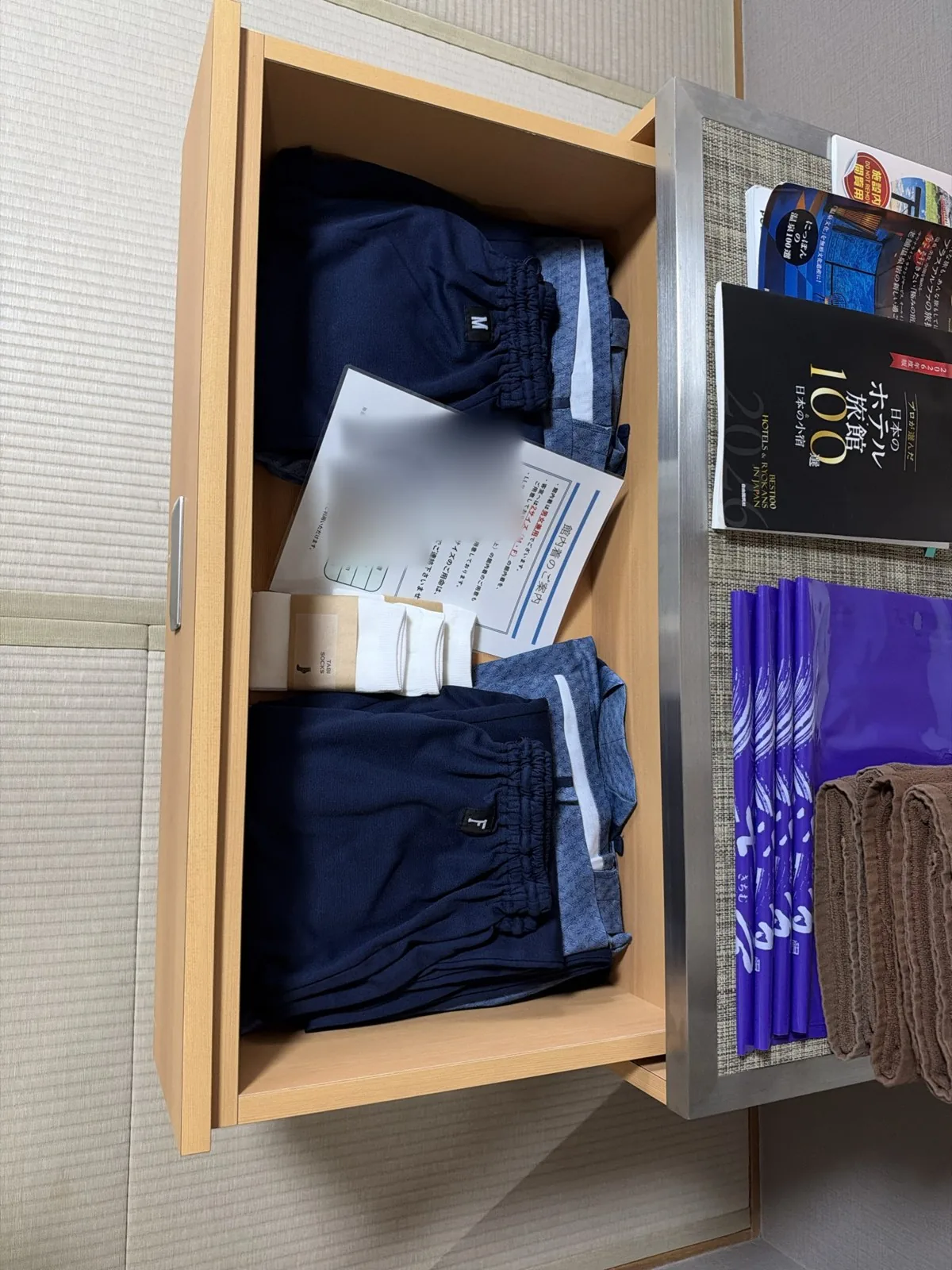 引き出しに用意された紺の館内着とタオル