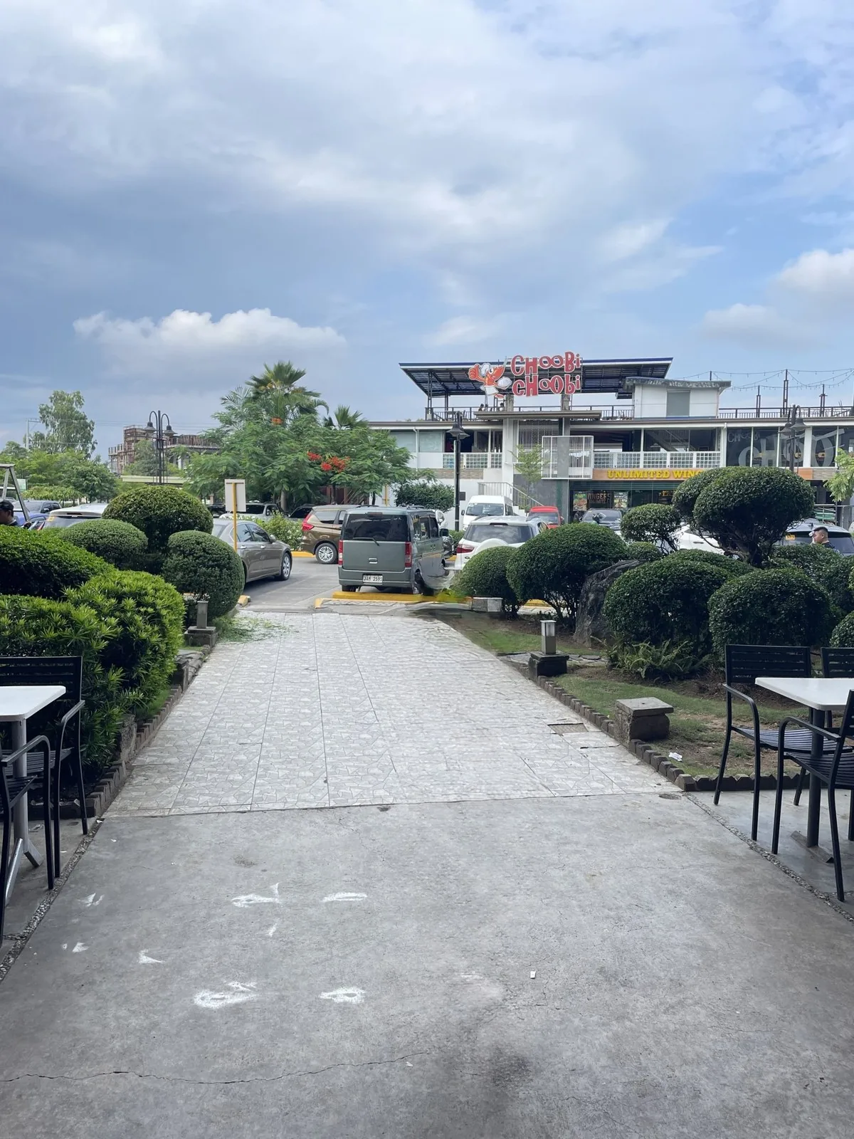 パークモールの敷地の小道。植え込みと屋外の席の先にモールの建物が見える