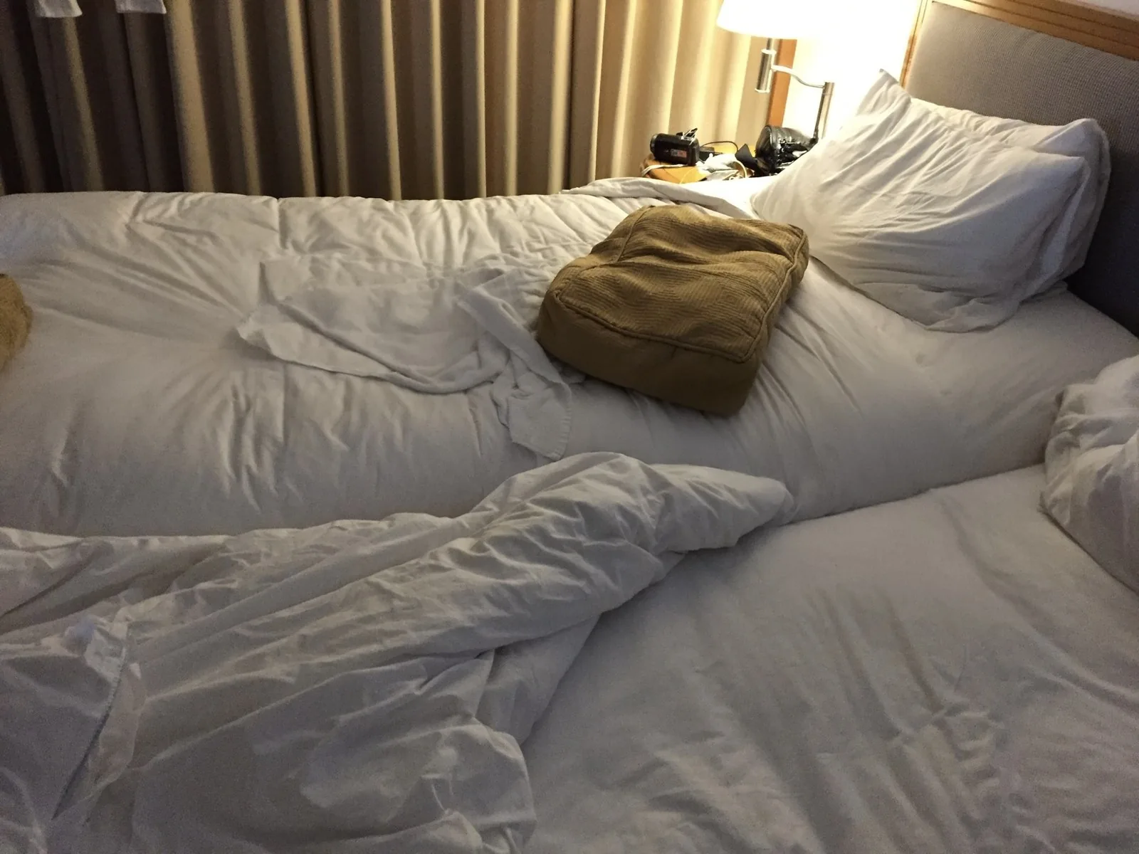 朝の光が差し込む、白いシーツのツインルームのベッド