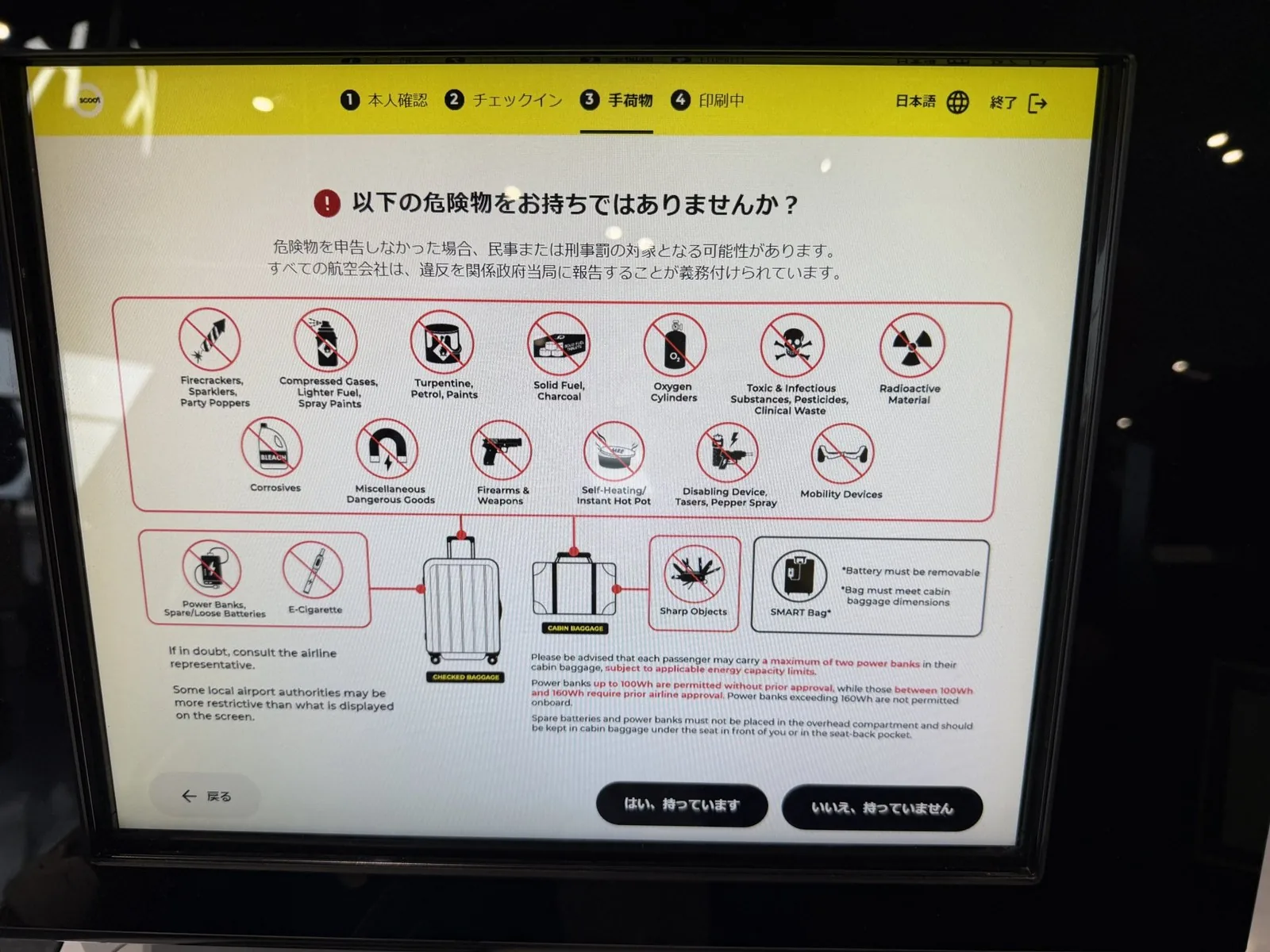 Scoot automated check-in machine screen showing an illustrated list of dangerous goods that cannot be taken on board, with a confirm button below